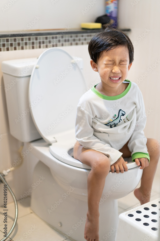 A Boy Is Sitting On Toilet With Suffering Stock Photo Adobe Stock
