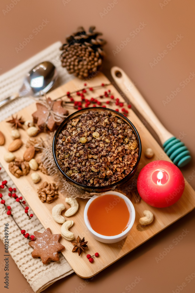 Kutia is a sweet wheat porridge of the Slavs. Traditional Christmas dish of the orthodox christians. Christmas kutia with honey, nuts, poppy, raisins and spices. Christmas eve food. Top view. Kutia is a sweet wheat porridge of the Slavs. Traditional Christmas dish of the orthodox christians. Christmas kutia with honey, nuts, poppy, raisins and spices. Christmas eve food. Top view.