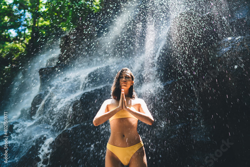 Thoughtful slim woman praying near waterfall © BullRun