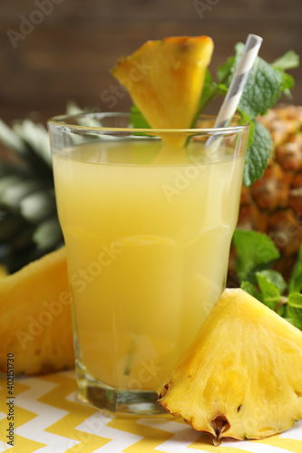 Fototapeta Naklejka Na Ścianę i Meble -  Delicious pineapple juice in glass and fresh fruit on table, closeup