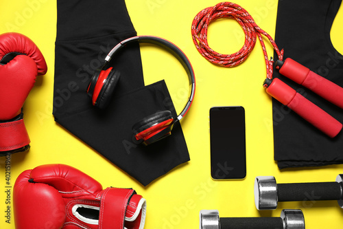 Stylish sportswear and equipment on yellow background, flat lay