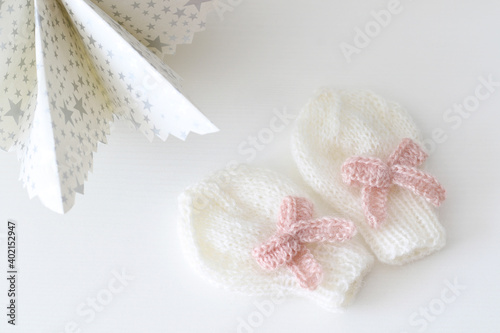 Fototapeta Naklejka Na Ścianę i Meble -  knitted white mittens with pink bow