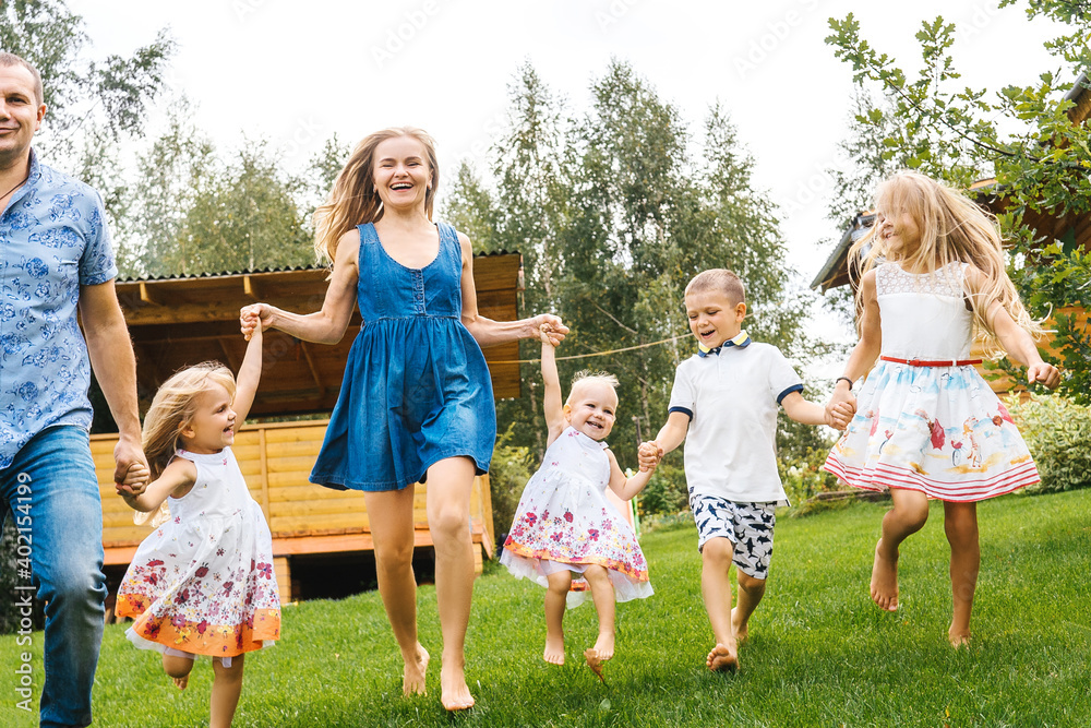 Happy family running in garden on grass.