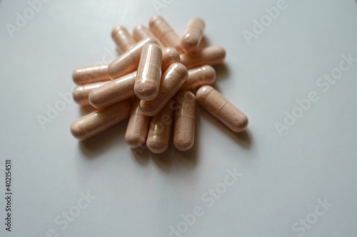 Handful of pink capsules of probiotic dietary supplement photo