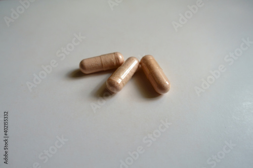 Peach colored capsules of probiotic dietary supplement (three items) photo