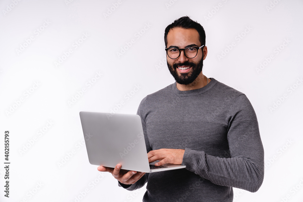 Happy confident young Middle East man using laptop isolated over white background Happy confident young Middle East man using laptop isolated over white background