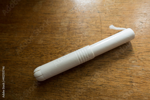 A tampon with cardboard applicator on wooden table
