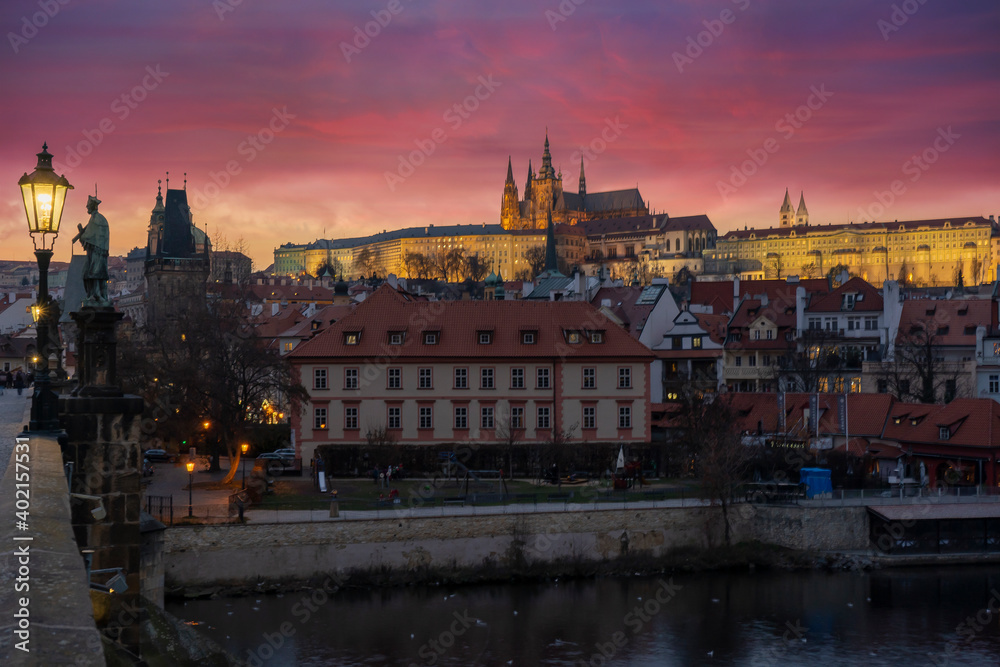 Fototapeta premium lamp at charles bridge and st. vita church lights from street lights are reflected on the surface of the vltava river in the center of prague at night in the czech republic