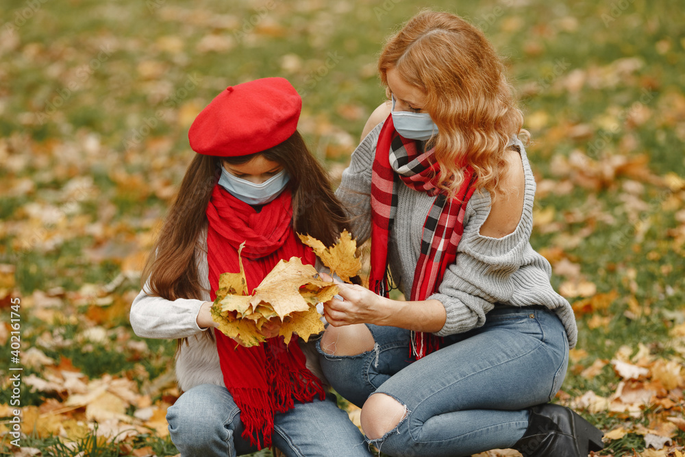Family in a autumn park. Coronavirus theme. Mother with daughter. Family in a autumn park. Coronavirus theme. Mother with daughter.