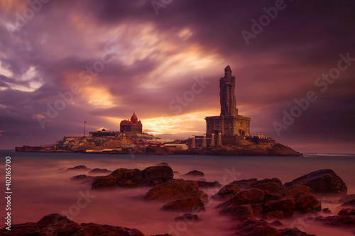 Kanyakumari - Vivekananda Rock Memorial Thiruvalluvar Statue in the evening with a colorful and cloudy sky background.