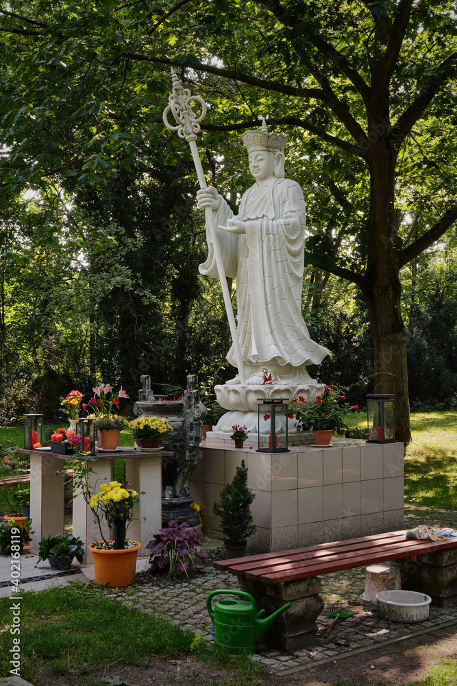 Obraz premium Bodhisattva-Statue auf dem buddhistischen Gräberfeld des Friedhofs Ruhleben im Berliner Westend