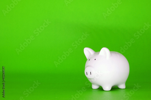 White Piggy bank on green background with copy space for text message - Fund , Investment , Saving money - green concept of Banking and Stable financial