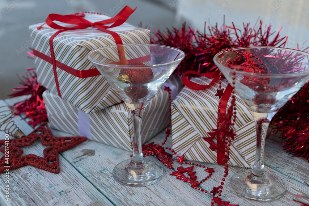 two martini glasses surrounded by new year gifts with red christmas  decorations on a blue wooden table. High quality photo Stock Photo | Adobe  Stock