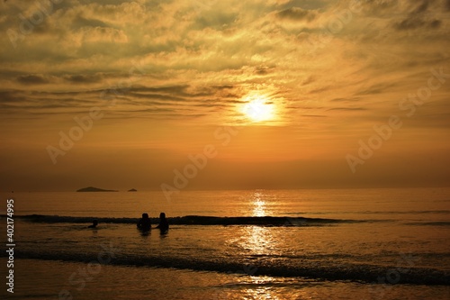 The rising sun view and the beach. Beautiful golden yellow sky and sun The view of the beach, the beach and the sun loungers are rising. Beautiful golden yellow sky and sun