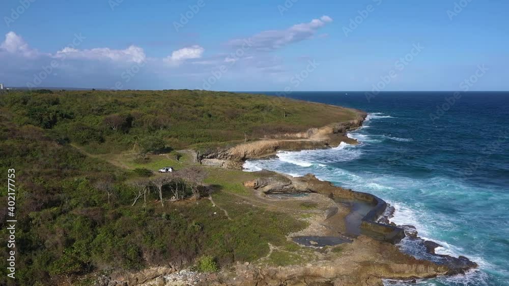 Aerial view going down towards the sea coast breaking the rocks on a windy day moving the waves Aerial view going down towards the sea coast breaking the rocks on a windy day moving the waves
