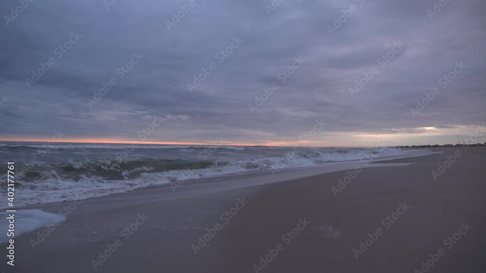 Stormy Weather At The Beach With Rough Sea And Overcast Dramatic Sky During Sunset Slow Motion - Wide Static Shot Stormy Weather At The Beach With Rough Sea And Overcast Dramatic Sky During Sunset Slow Motion - Wide Static Shot