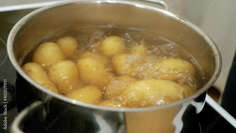 Boiling potatoes are checked with a knife to see whether they are ready Boiling potatoes are checked with a knife to see whether they are ready
