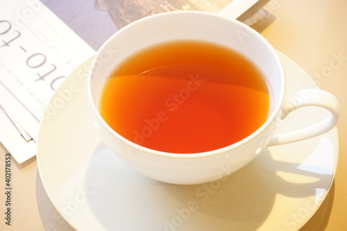 Cup of English Tea isolated on white saucer with Paper magazine - 紅茶 白いカップ、ソーサーと新聞