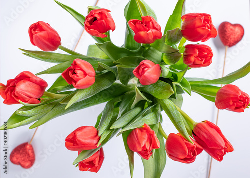 St Valentines day composition with bouquet of tullips and two red hearts