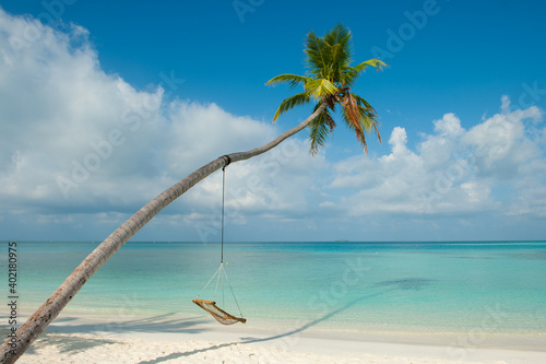 Tropical beach paradise as summer landscape with beach swing or hammock and white sand. Luxury beach scene vacation summer holiday. Exotic island nature travel destination