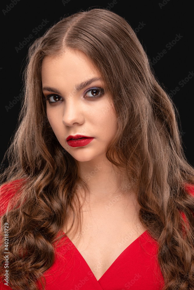 Brunette girl with beautiful makeup, with clean skin, long curly hair wearing a red dress. Brunette girl with beautiful makeup, with clean skin, long curly hair wearing a red dress.