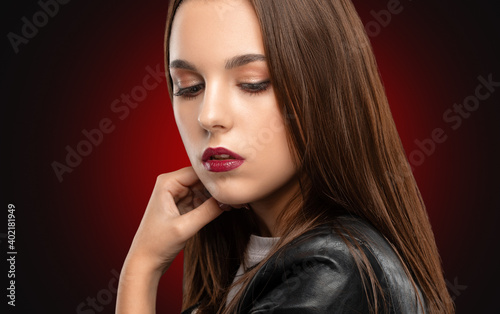 Brunette girl with beautiful makeup, with clean skin, long hair in a black leather jacket. makeup concept