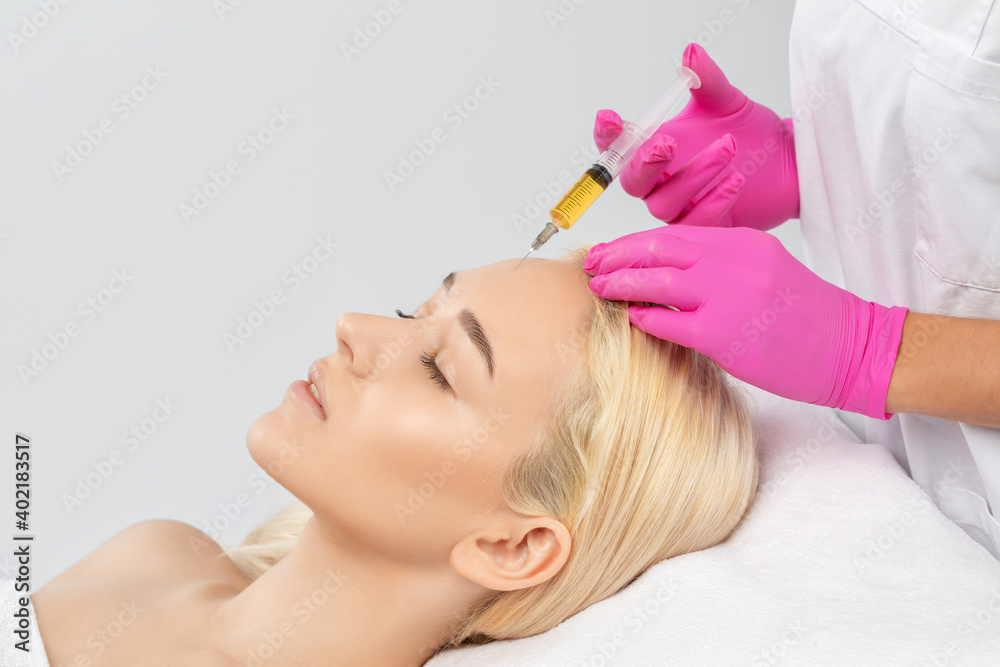 Cosmetologist does prp therapy on the face of a beautiful woman in a beauty salon. Cosmetology concept. Cosmetologist does prp therapy on the face of a beautiful woman in a beauty salon. Cosmetology concept.