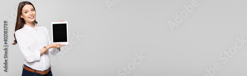  young pregnant businesswoman presenting digital tablet isolated on grey, banner