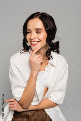  brunette woman in white top and shirt looking away isolated isolated on grey