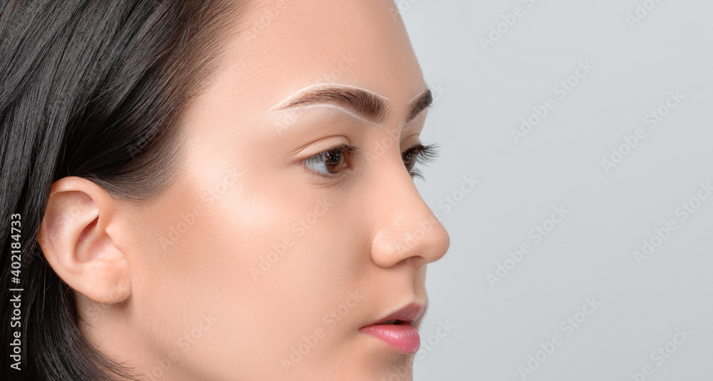 Permanent make-up for eyebrows of beautiful woman with thick brows in beauty salon. Closeup beautician doing tattooing eyebrow. Professional makeup and cosmetology skin care. Permanent make-up for eyebrows of beautiful woman with thick brows in beauty salon. Closeup beautician doing tattooing eyebrow. Professional makeup and cosmetology skin care.