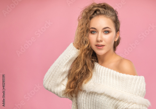 Beautiful red-haired girl with beautiful makeup, with clean skin, long hair in a winter sweater. New Year concept