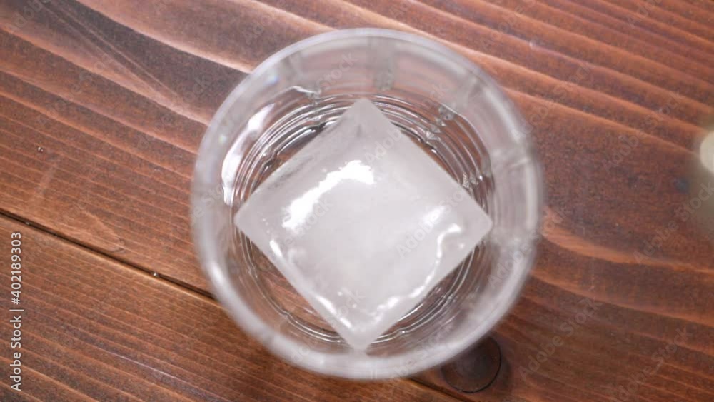 Whiskey being poured into a glass with ice in slow motion HD Whiskey being poured into a glass with ice in slow motion HD