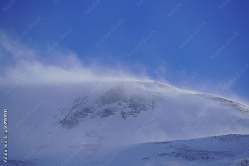strong south wind in the alps in winter on a sunny day in the national park hohe tauern in austria