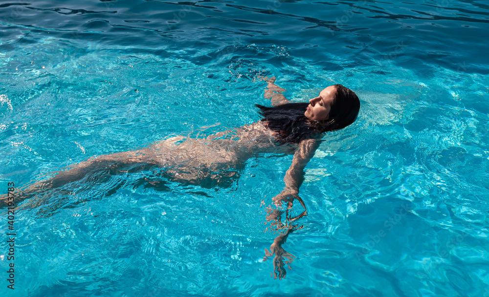 Nude woman in swimming pool