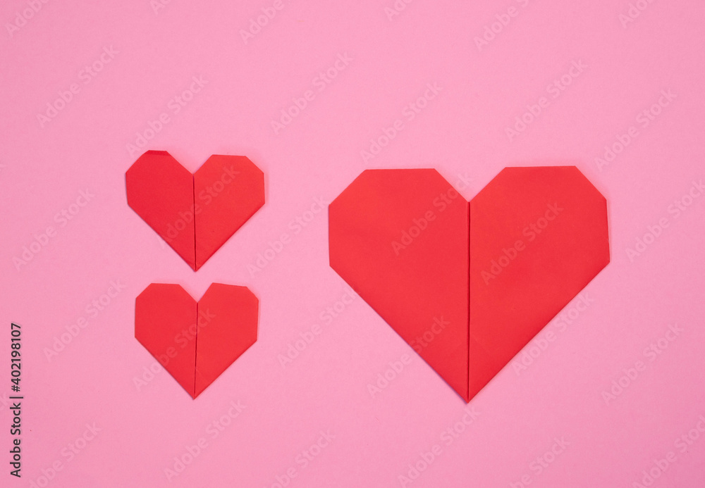 Love. Three red hearts on a pink background