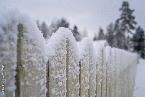 Snow on a wooden fence after snowfall. Blurred background, selective focus. 