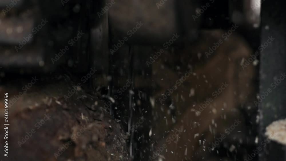 production of wooden lumber and planks. A sawmill saws a log into planks. sawdust flying slow motion. High quality FullHD footage