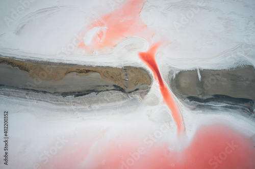 Top view of the surface of a salt lake with a pink abstract pattern similar to marble. The natural background.