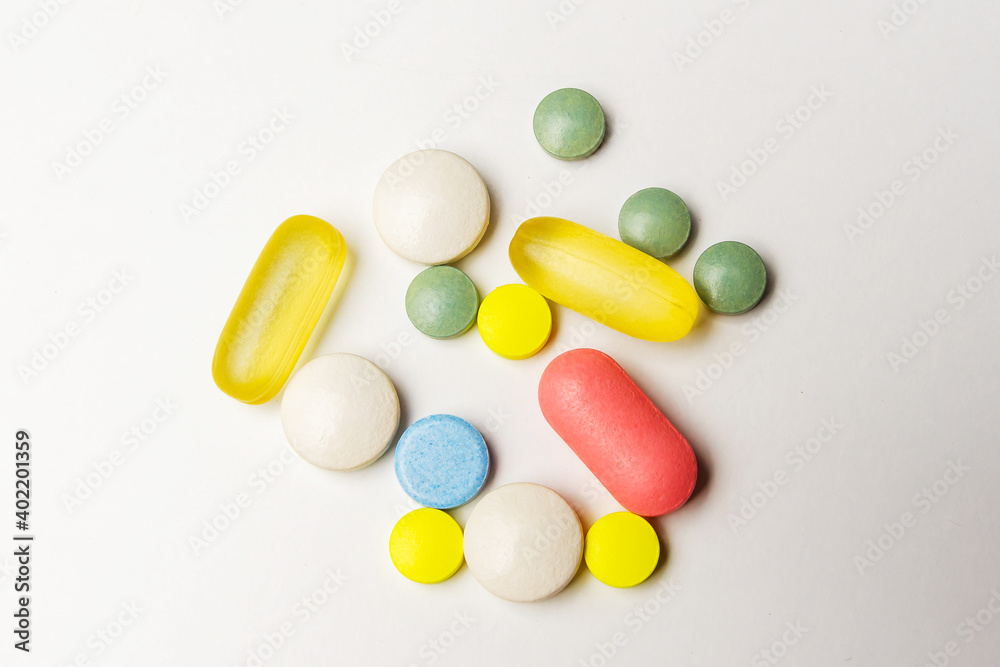 Colorful pills vitamins and antibiotics lie beautifully on a white background Colorful pills vitamins and antibiotics lie beautifully on a white background