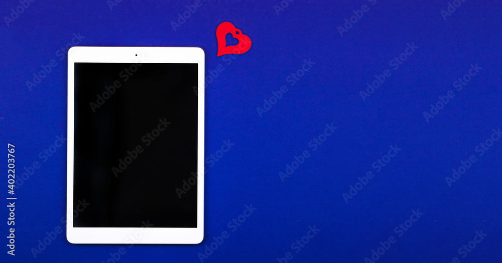 Concept of receiveing new likes and followers, tablet on blue background with copy space Concept of receiveing new likes and followers, tablet on blue background with copy space