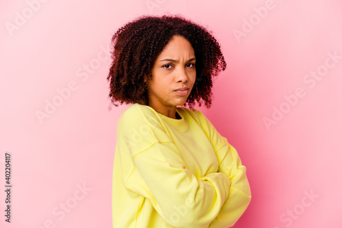 Young african american mixed race woman isolated frowning face in displeasure, keeps arms folded.