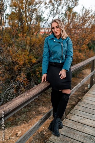 Chica rubia feliz en un bosque de otoño invierno al sur de españa vestida a la moda llamativa casual