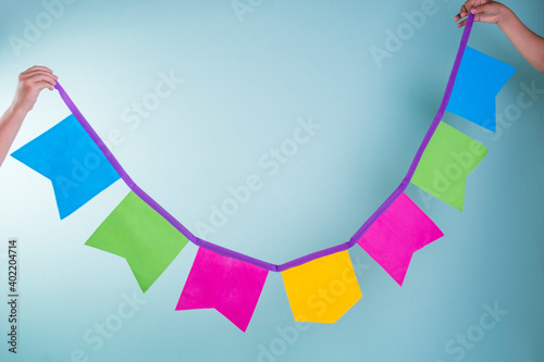 Children's hands hold a colorful garland