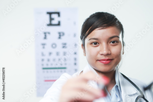 A female doctor with stethoscope and a vision chart