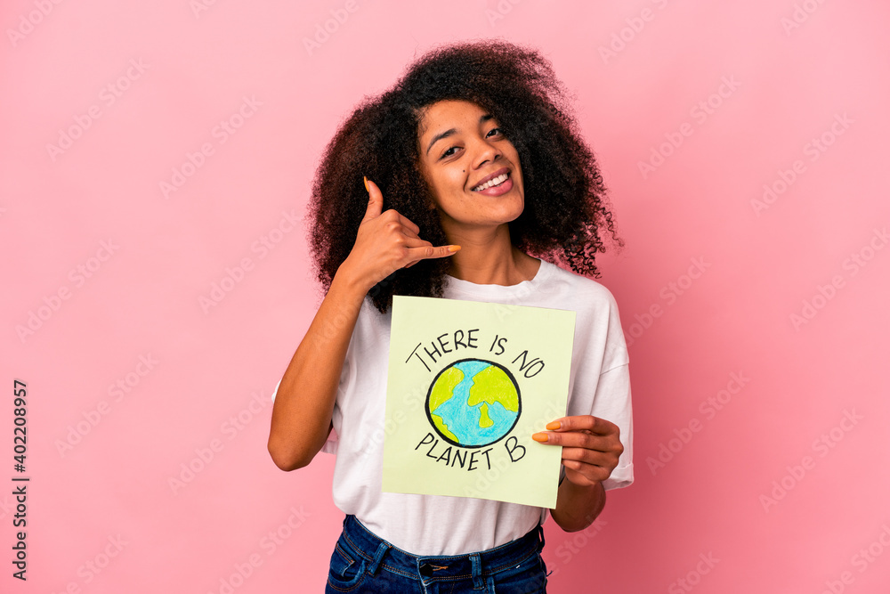 Young african american curly woman holding a planet message on a placard showing a mobile phone call gesture with fingers. Young african american curly woman holding a planet message on a placard showing a mobile phone call gesture with fingers.