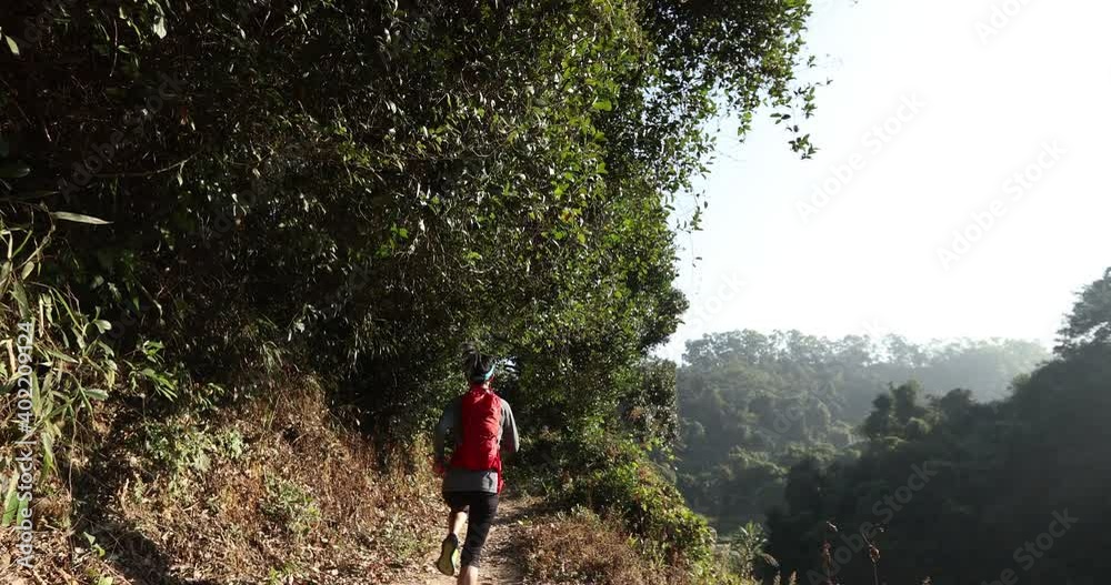 Woman trail runner running at sunrise tropical forest Woman trail runner running at sunrise tropical forest