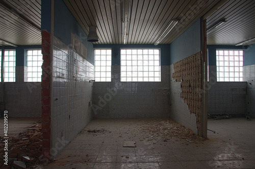 Abandoned building interior with large glass block windows.