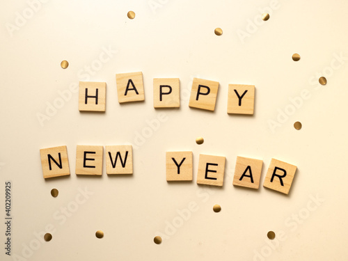Happy new year - napis z drewnianych kostek, confetti, białe tło, flatlay 