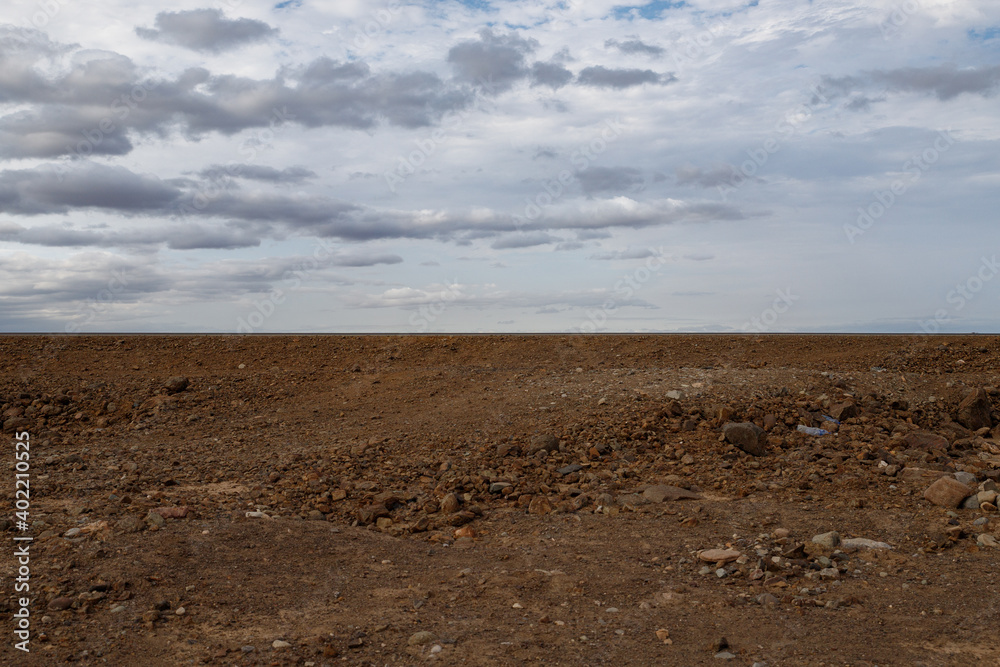 the Ethiopian desert where the earth is brown and the sky is dramatically dark moaning in contrast