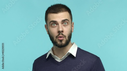 Close up of handsome guy taking off glasses and stare surprised at camera, see something amazing, saying wow with impressed face, standing over blue background